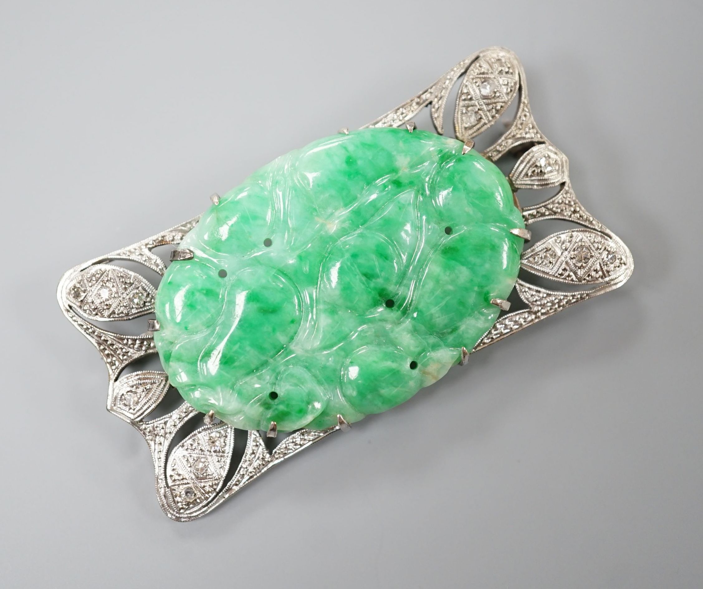 A white metal (stamped 9C?), diamond chips and oval carved jade set shaped rectangular brooch, 52mm, gross weight 13.1 grams.